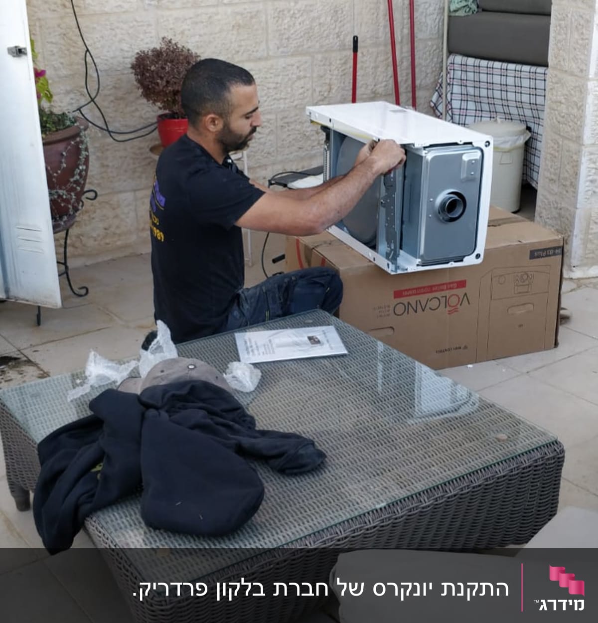 אדם מתקין מכשיר על קופסת קרטון של וולקנו